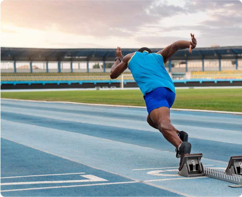 Foto de chico corriendo en pista de atletismo.